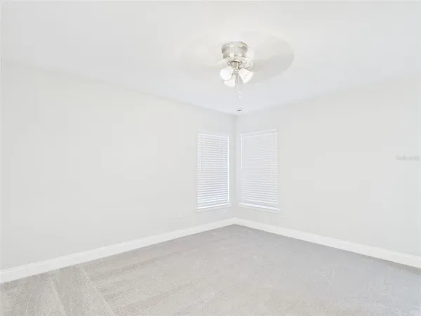 an empty room with a chandelier fan