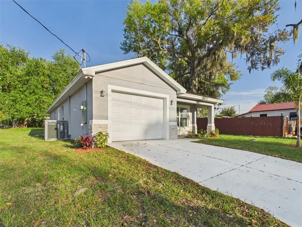 a front view of house with yard and trees around