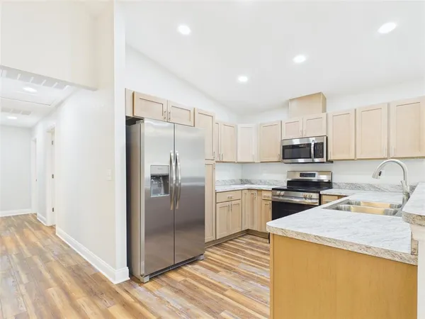 a kitchen with a refrigerator a stove a sink and a cabinets