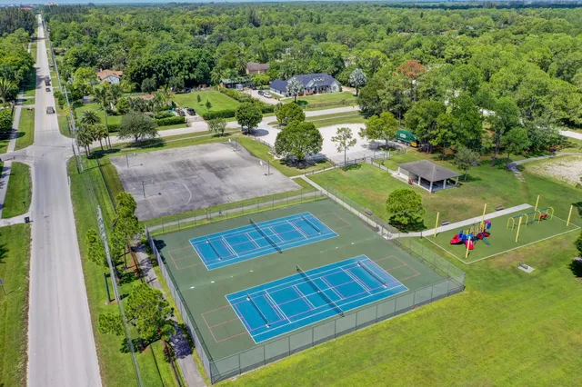 view of a tennis ground with large trees
