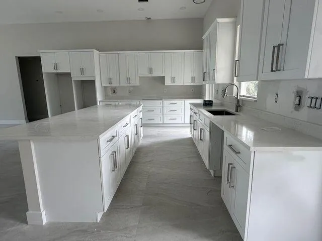 a kitchen with granite countertop white cabinets and window