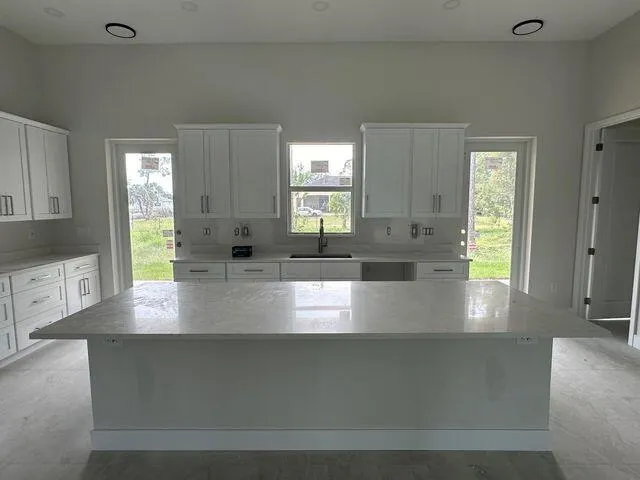 a large white kitchen with a sink