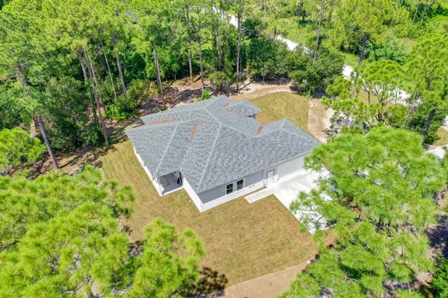 an aerial view of a house with swimming pool and garden view
