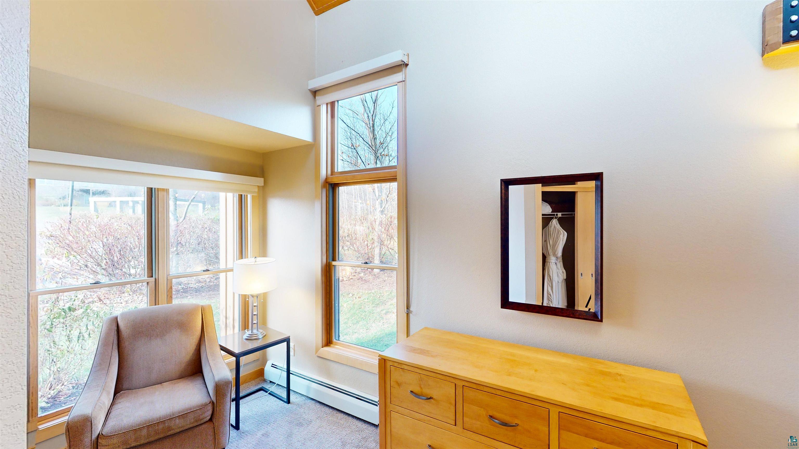40 Surfside Drive, Unit 5D Tofte, MN 55615 - Photo 13 of 37 Interior space featuring multiple windows, a high vaulted ceiling, and wood-finish window frames
