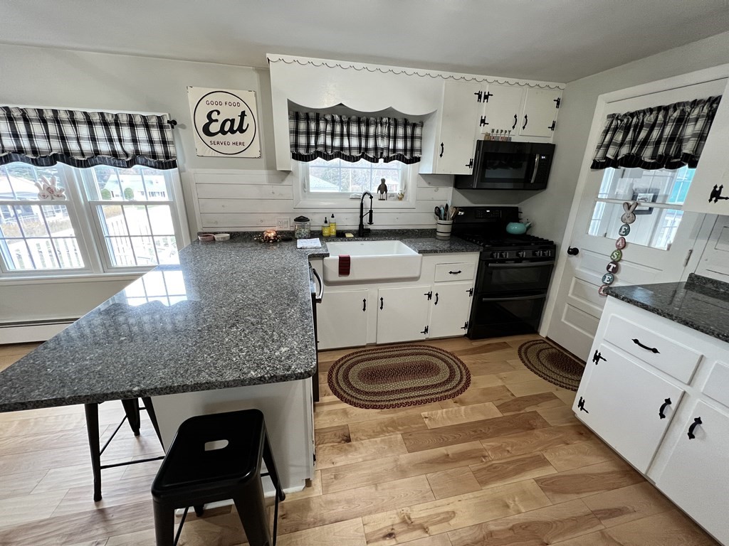 12 Sawmill Road Dudley, MA 01571 - Photo 14 of 37 a kitchen with stainless steel appliances a stove a sink cabinets and a window