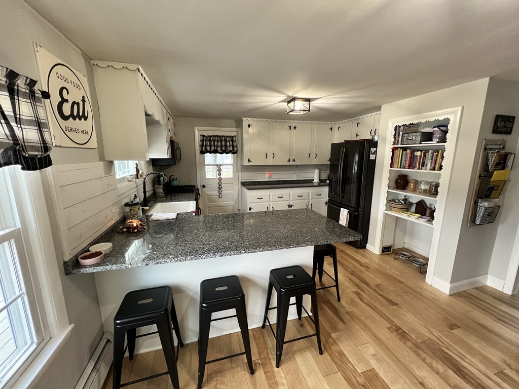 12 Sawmill Road Dudley, MA 01571 - Photo 15 of 37 a kitchen with stainless steel appliances granite countertop a table chairs and a refrigerator