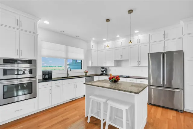 a kitchen with a sink stainless steel appliances and white cabinets