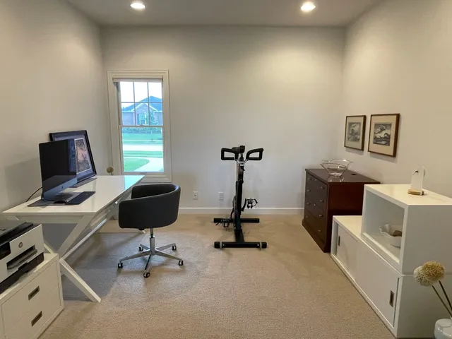 a view of a workspace with furniture and a window