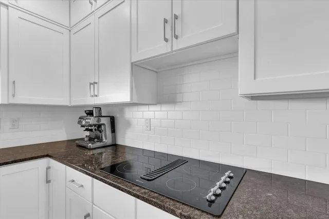 a kitchen with granite countertop white cabinets and a white stove