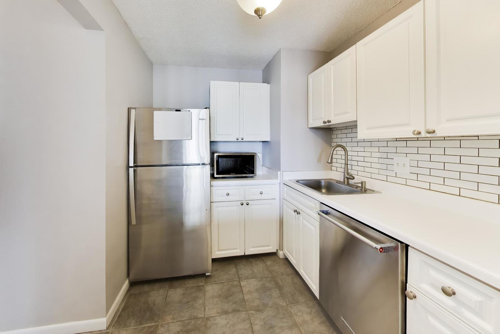 111 West Maple Street, Unit 1503 Chicago, IL 60610 - Photo 16 of 39 a kitchen with white cabinets and white appliances