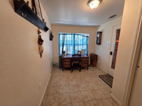 a kitchen with a table chairs microwave and cabinets