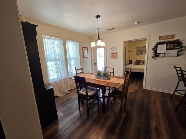 a kitchen with granite countertop a table chairs stove and refrigerator