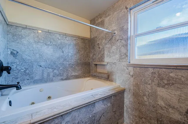 a bathroom with a bathtub and a shower