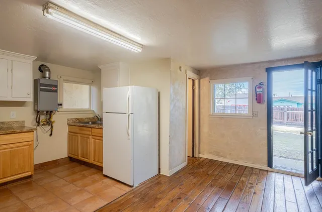 a kitchen with a refrigerator stove and wooden floor