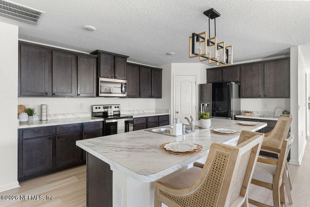 75394 Bridgewater Drive Yulee, FL 32097 - Photo 20 of 55 a view of kitchen with sink refrigerator dining table and chairs