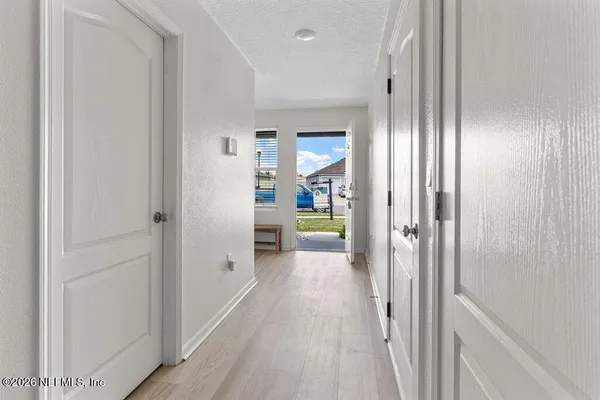 a view of a hallway with wooden floor and closet area
