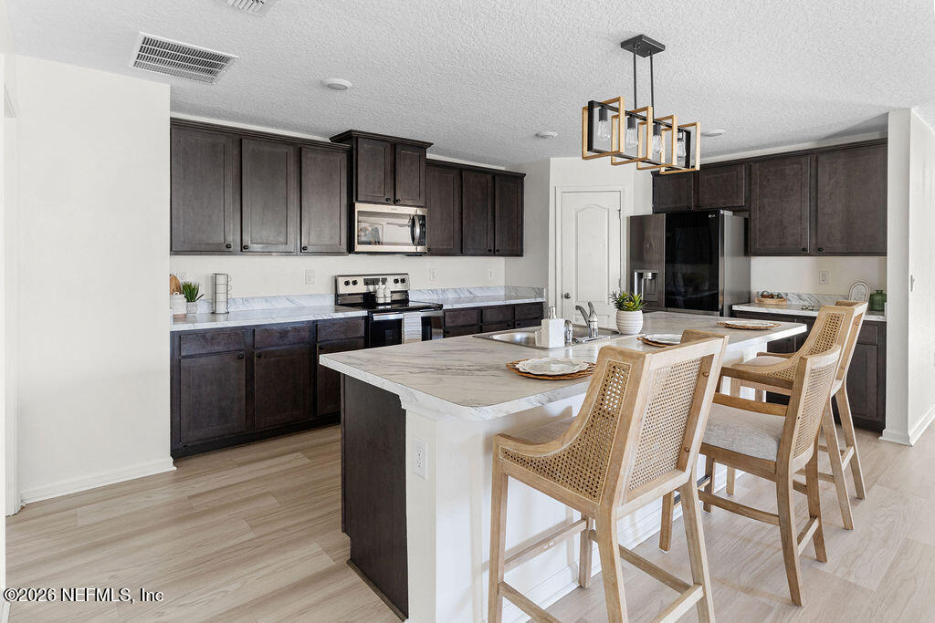 75394 Bridgewater Drive Yulee, FL 32097 - Photo 21 of 55 a view of a dining room with furniture and chandelier