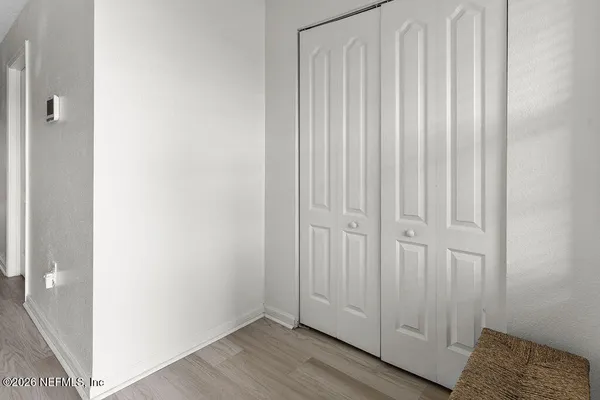 a view of a closet area with hardwood floor