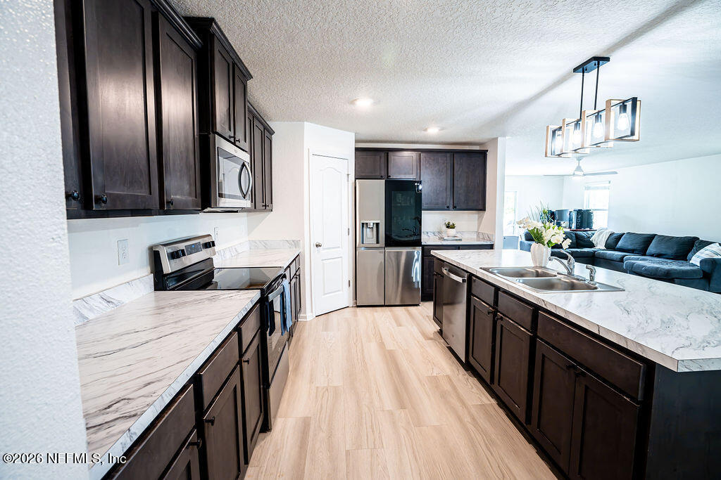 75394 Bridgewater Drive Yulee, FL 32097 - Photo 37 of 55 a large kitchen with a center island wooden floor stainless steel appliances and cabinets