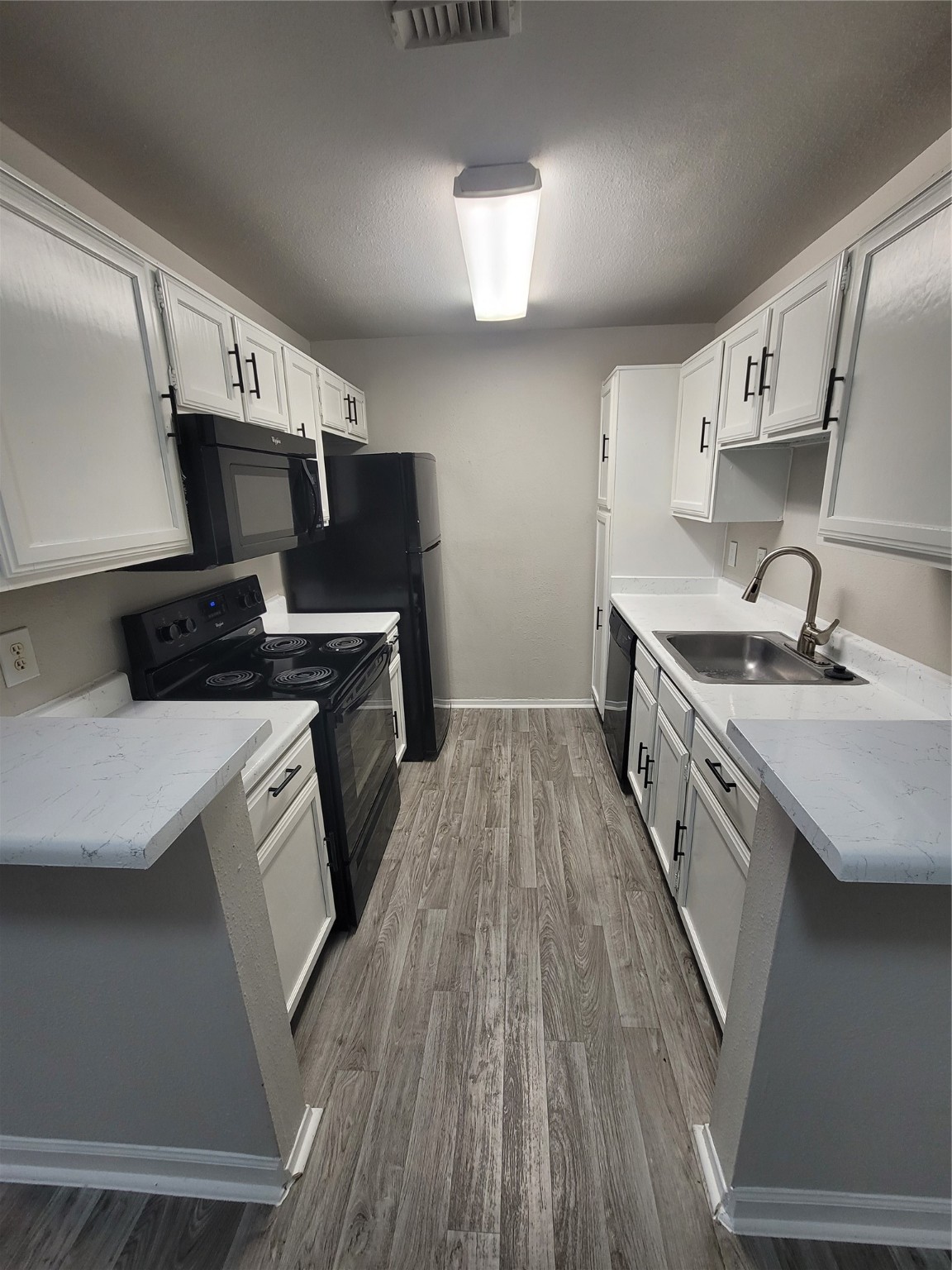 7250 West Greens Road, Unit 108 Houston, TX 77064 - Photo 5 of 9 a kitchen that has a sink a stove and cabinets