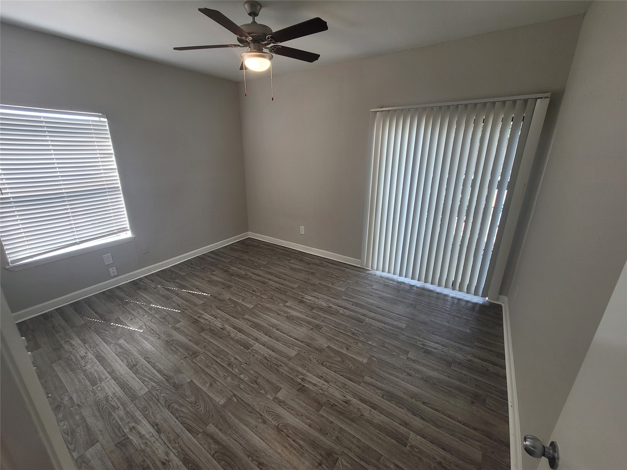 7250 West Greens Road, Unit 108 Houston, TX 77064 - Photo 8 of 9 an empty room with wooden floor fan and windows