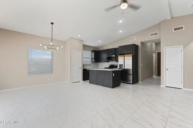 a large kitchen with kitchen island a sink stainless steel appliances and cabinets