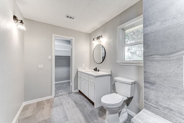 a bathroom with a toilet sink and mirror