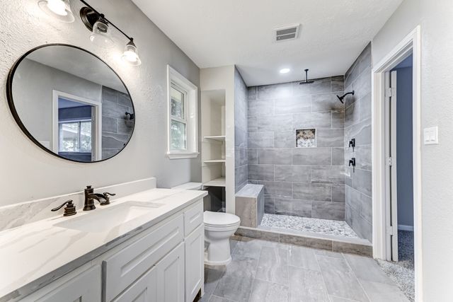 a bathroom with a double vanity sink mirror and shower
