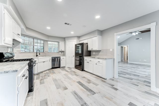 a kitchen with white cabinets and stainless steel appliances