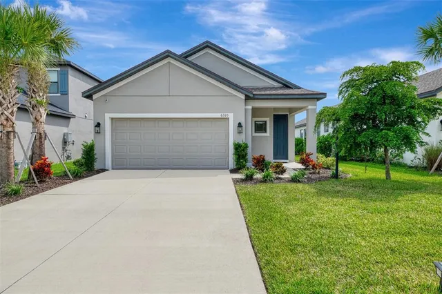a front view of a house with yard and green space