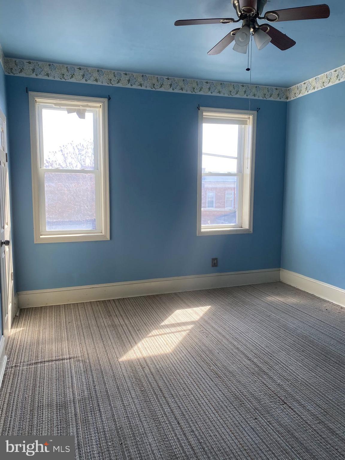 610 Rappolla Street Baltimore, MD 21224 - Photo 14 of 22 an empty room with wooden floor chandelier fan and windows