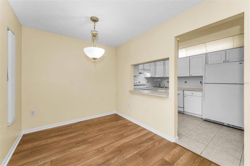 2687 Pine Ridge Way South, Unit F2 Palm Harbor, FL 34684 - Photo 14 of 62 a kitchen with white cabinets and refrigerator