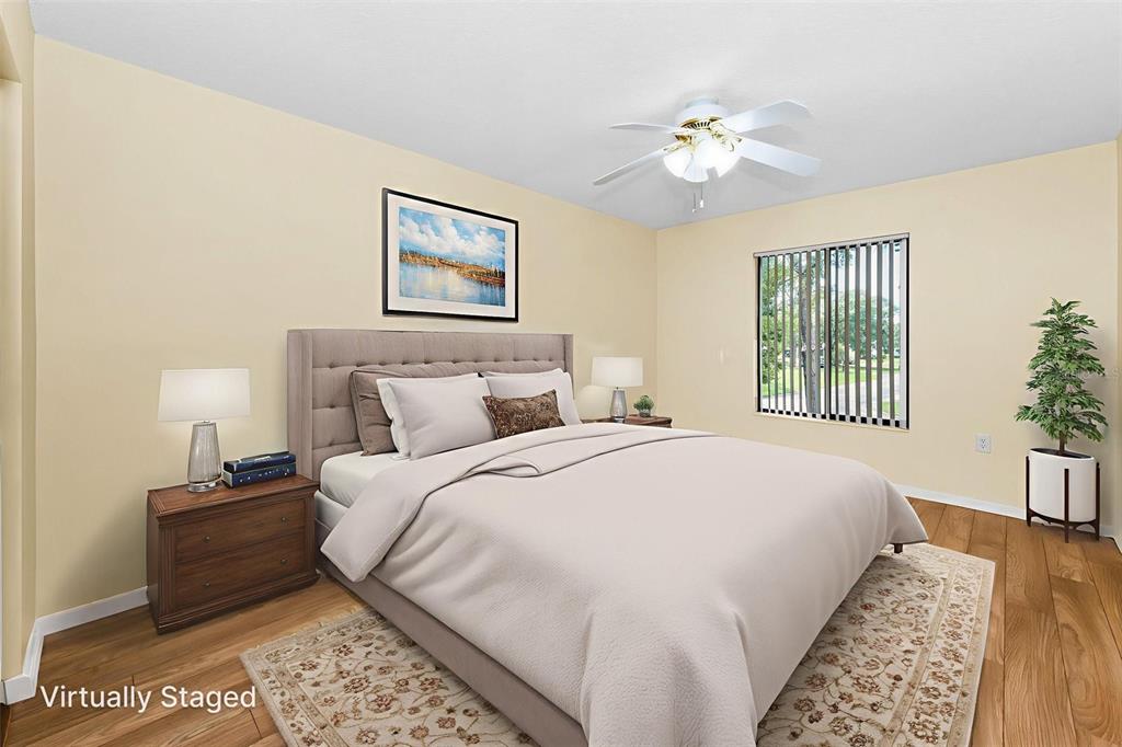 2687 Pine Ridge Way South, Unit F2 Palm Harbor, FL 34684 - Photo 19 of 62 a bedroom with a large bed and a chandelier