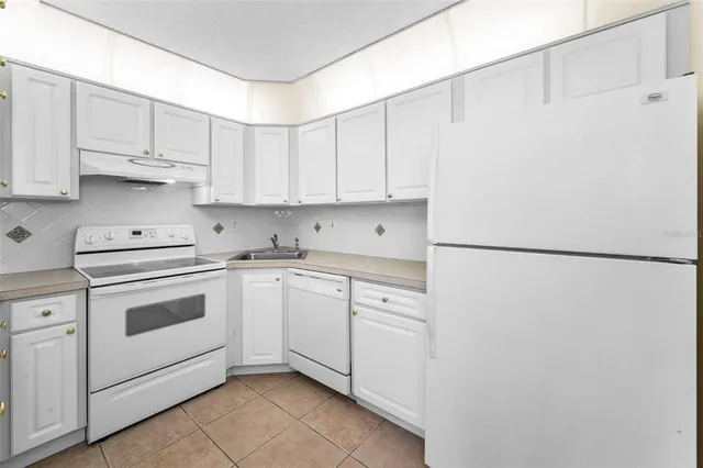 a view of an empty room with wooden floor and a ceiling fan