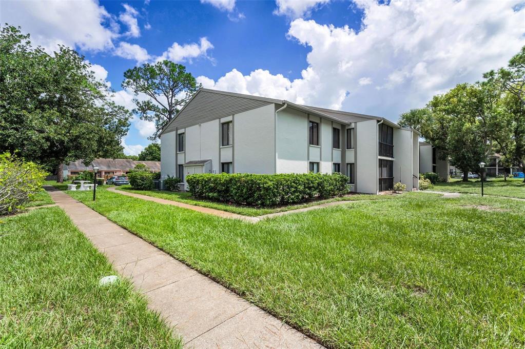 2687 Pine Ridge Way South, Unit F2 Palm Harbor, FL 34684 - Photo 36 of 62 a front view of house with yard and green space