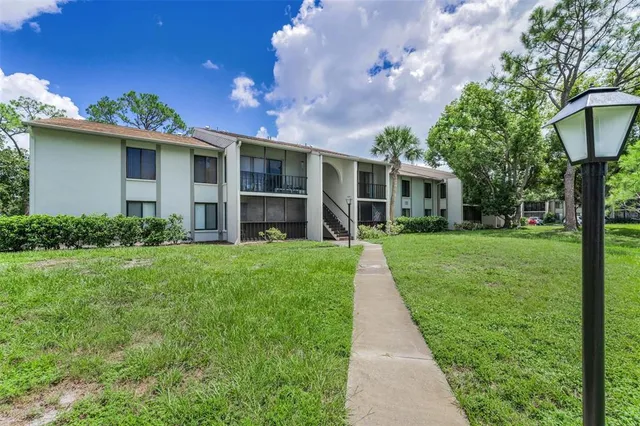 a front view of a house with a yard and potted plants