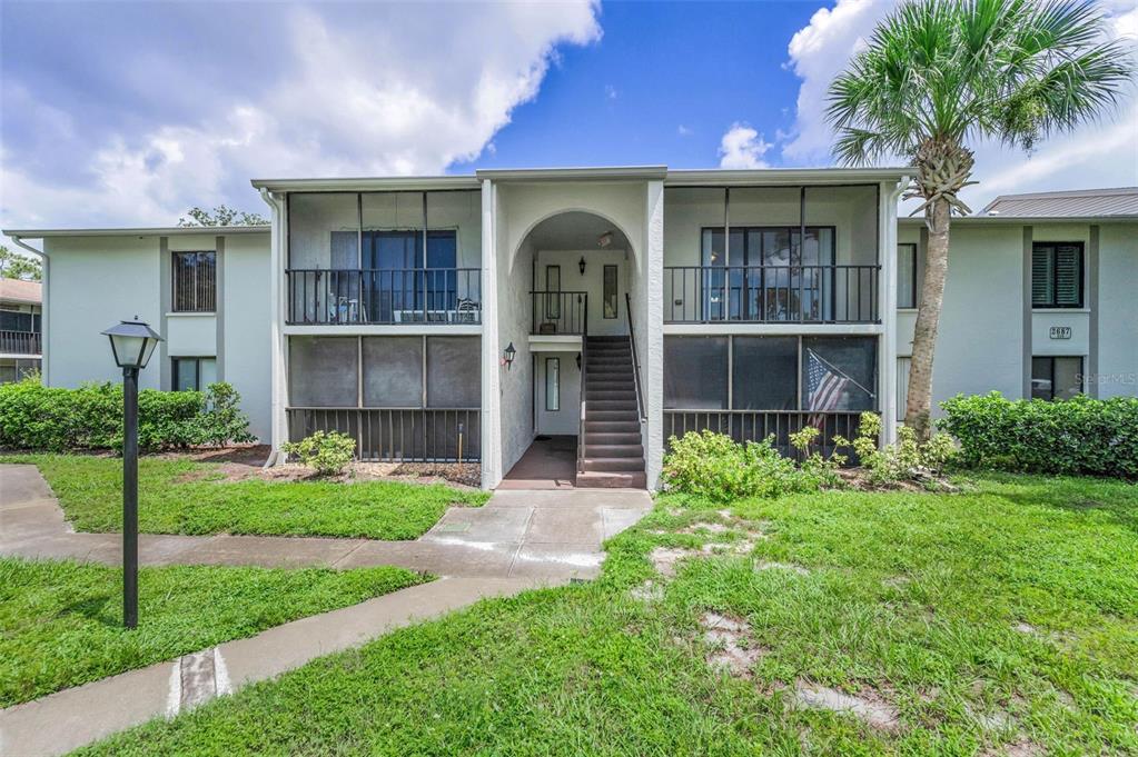 2687 Pine Ridge Way South, Unit F2 Palm Harbor, FL 34684 - Photo 8 of 62 a front view of a house with a garden