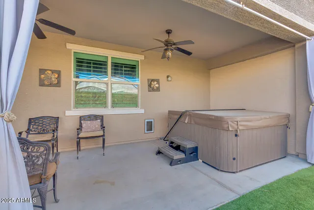 a living room with patio furniture and a large window