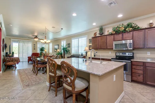 a kitchen with sink a microwave and chairs