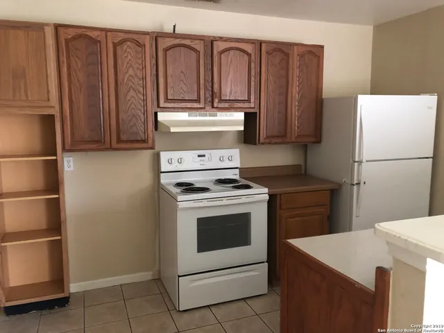 a kitchen with a stove and a refrigerator