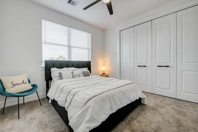 a bed sitting in a spacious bedroom next to a window