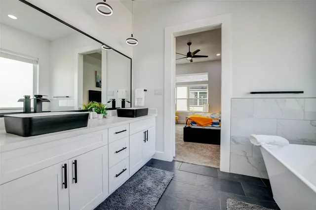 a bathroom with a white tub a window and a shower