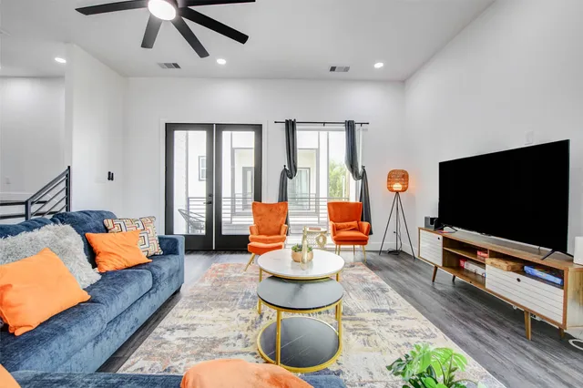 a living room with furniture and a wooden floor