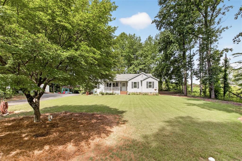 3771 Castleberry Road Cumming, GA 30040 - Photo 50 of 69 a front view of a house with a yard and trees