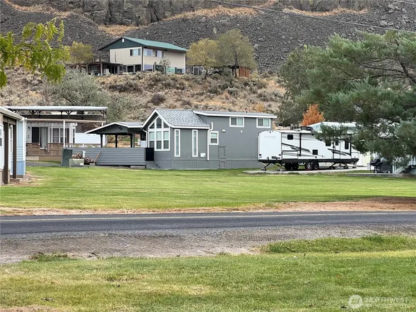 a view of a house with a big yard and large trees