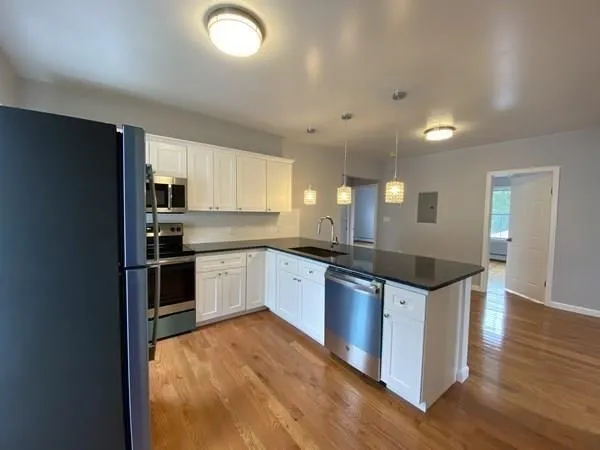 a large kitchen with stainless steel appliances granite countertop a stove and a sink