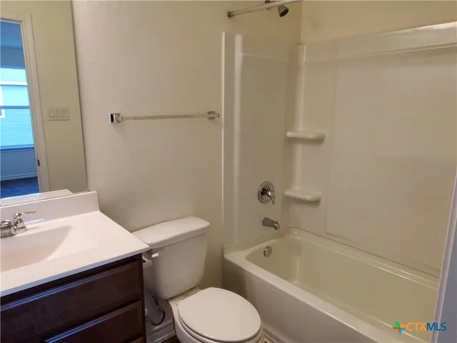 a white toilet sitting next to a bath tub
