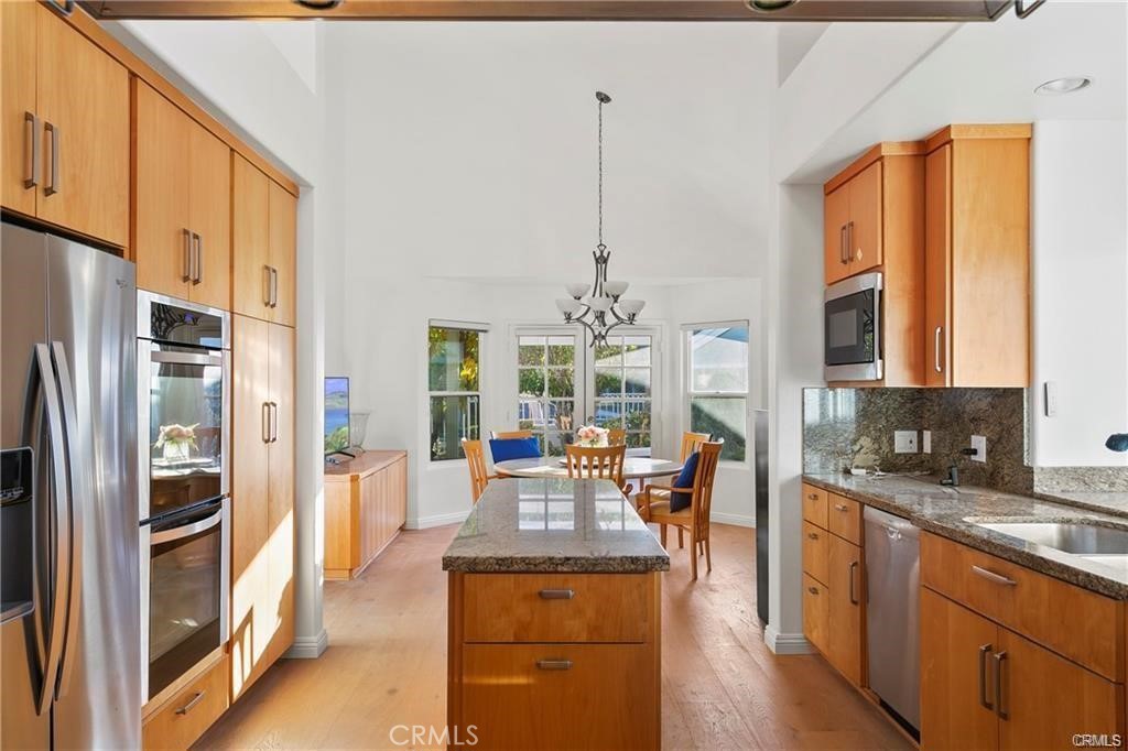 5 Argo Irvine, CA 92603 - Photo 7 of 24 a kitchen with stainless steel appliances granite countertop a refrigerator a stove and a wooden floors