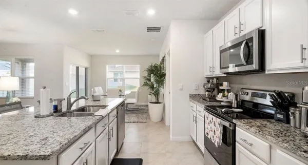 a kitchen with stainless steel appliances granite countertop a sink stove and cabinets