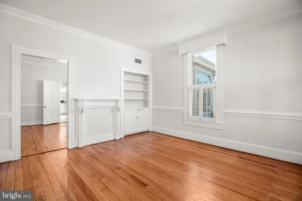 a view of empty room with wooden floor